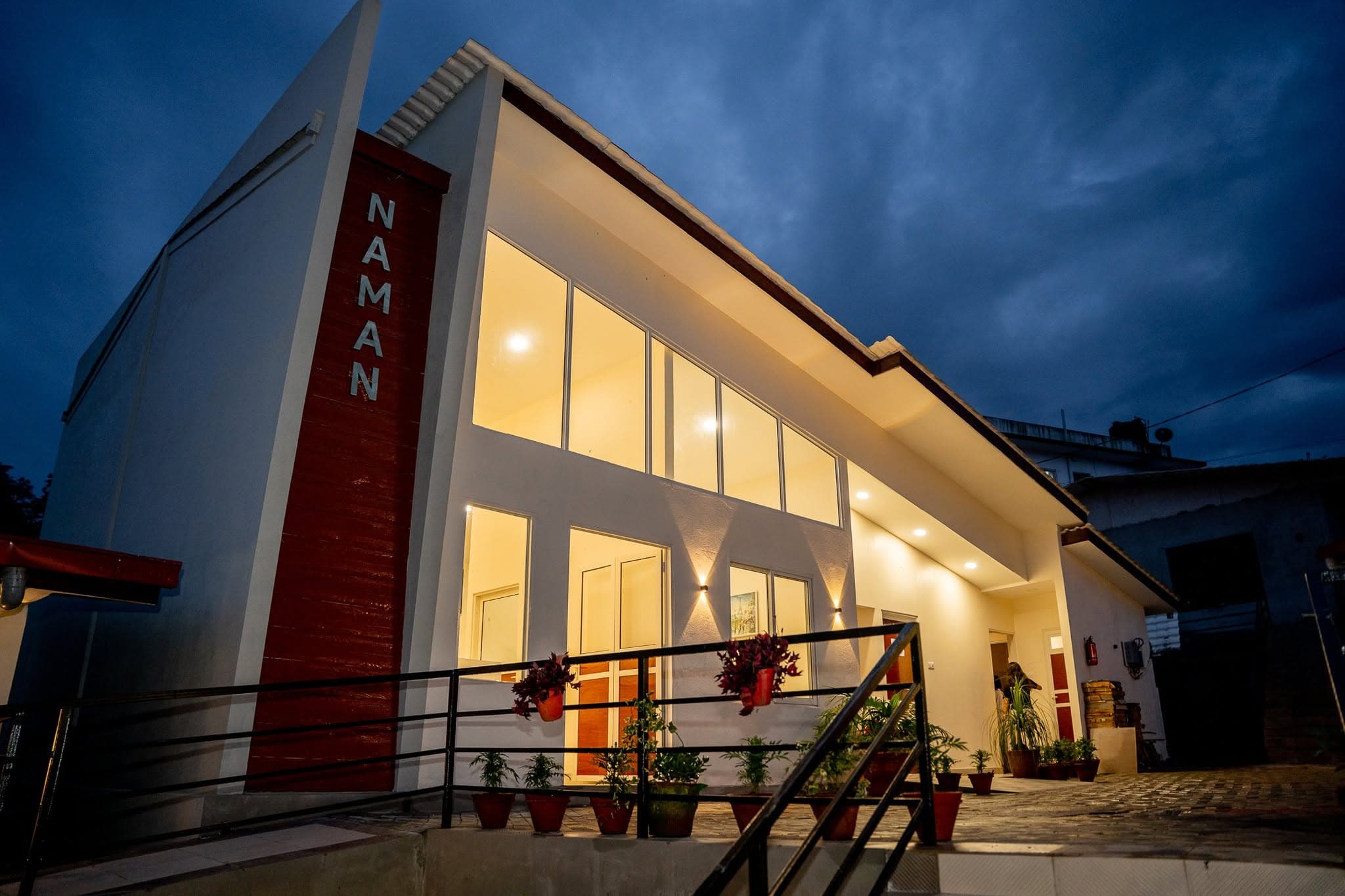 The Naman Bansbari building at blue hour with the illuminated red NAMAN column