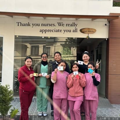 Naman nurses beneath the 'Thank you nurses' wall on International Nurses' Day