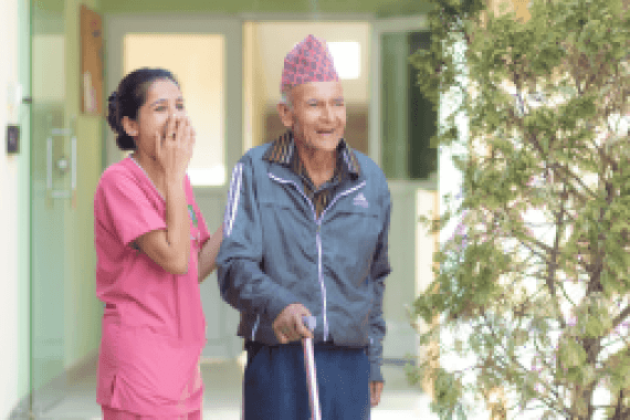 A caregiver and resident by the corridor at Naman Care Home