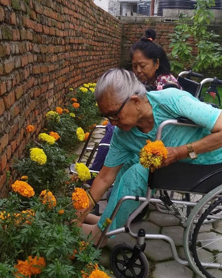 A Naman resident tending marigolds in the courtyard garden