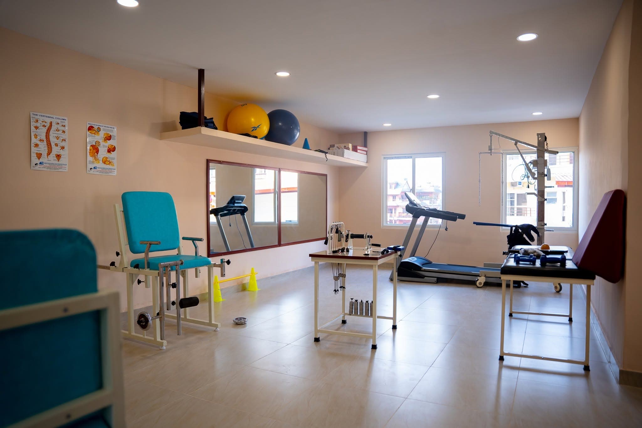 The Naman Bansbari physiotherapy gym with treadmill and spine posters — where stroke rehabilitation happens