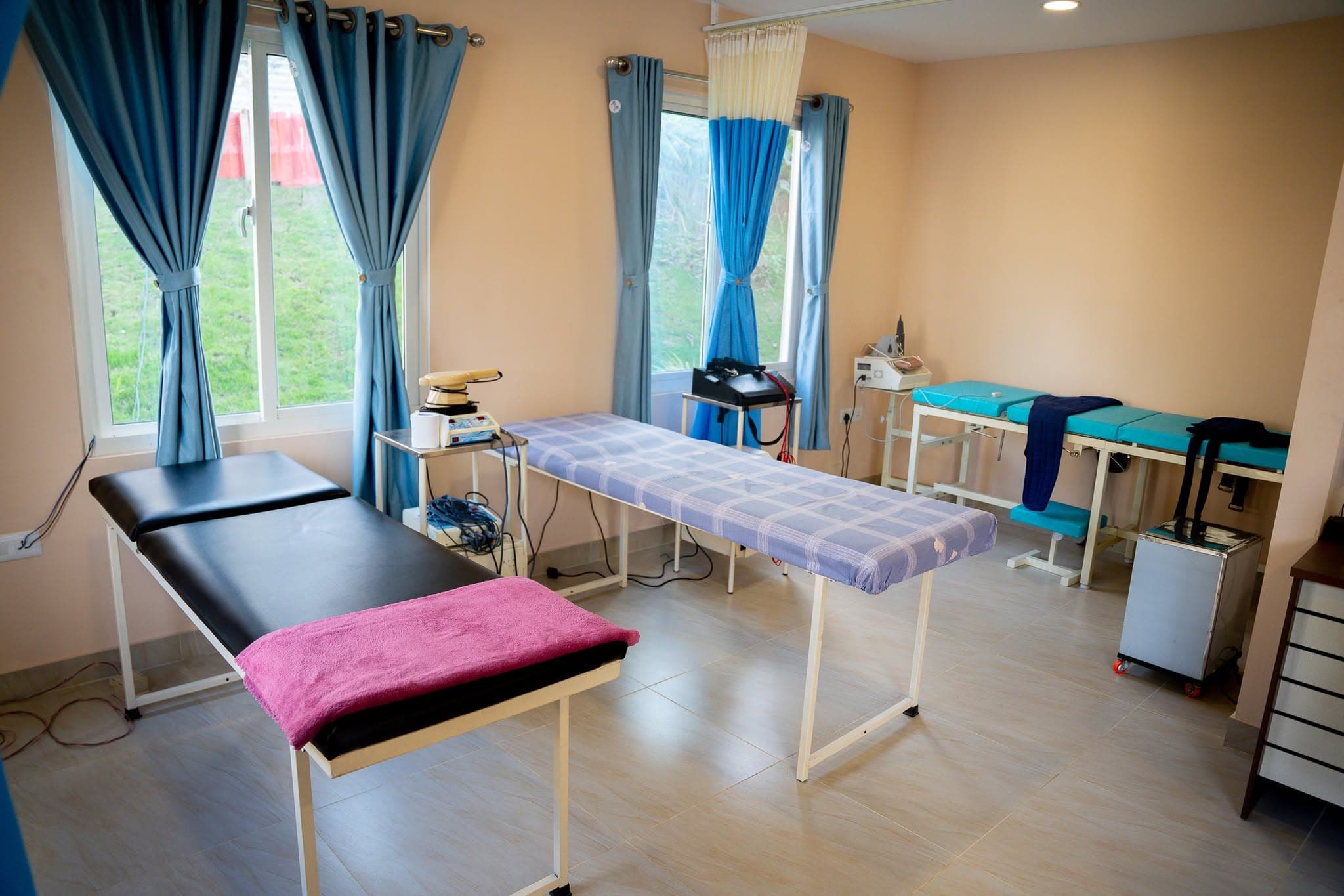 Therapy tables and IFT equipment in the Naman treatment room — where physiotherapy, acupuncture, and other therapies happen