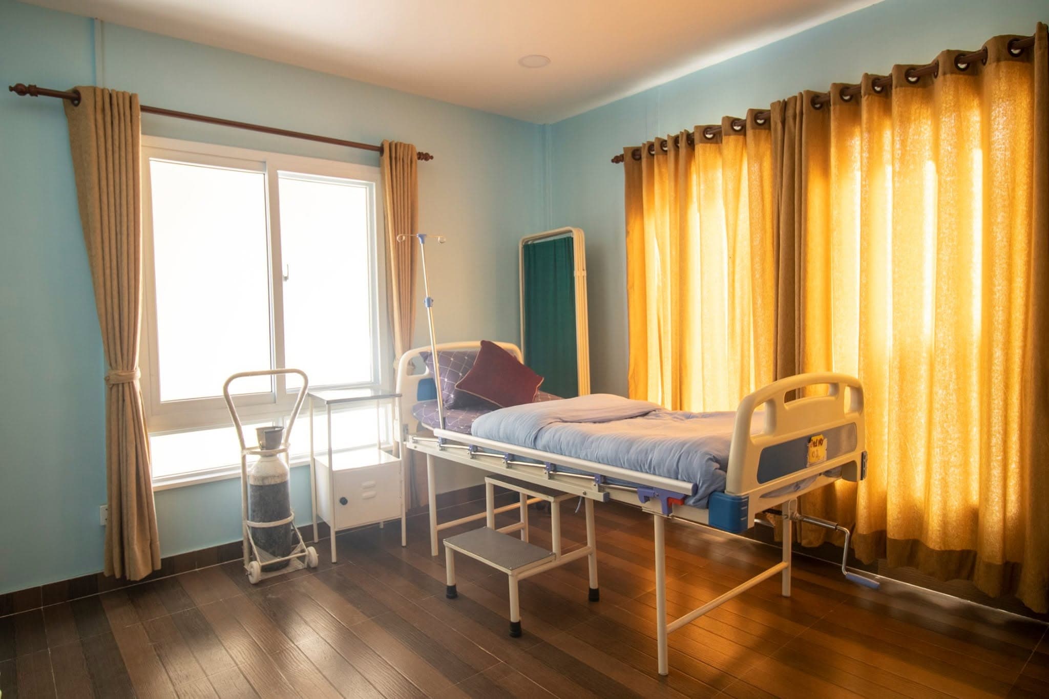 The High Care Unit at Naman Pipalbot — an adjustable medical bed with bedside oxygen cylinder and IV stand