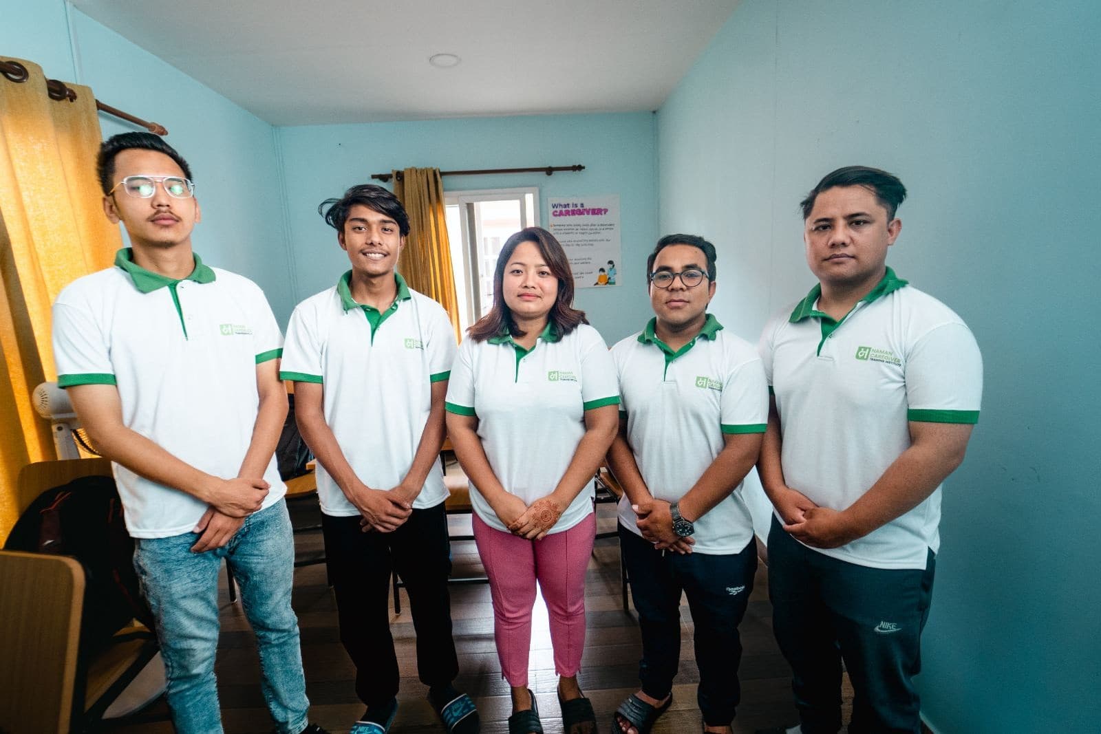 Five NCTI students in uniform standing together in the classroom